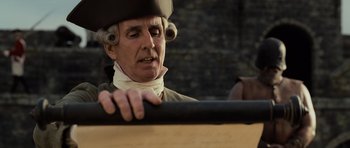Movie still from “Pirates of the Caribbean: The Curse of the Black Pearl” (2003), directed by Gore Verbinski – An old man wearing a hat is holding a wooden stick; Close Up shot, Over the shoulder angle