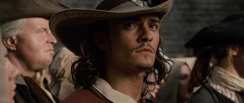 Movie still from “Pirates of the Caribbean: The Curse of the Black Pearl” (2003), directed by Gore Verbinski – A person with long hair wearing a hat; Close Up shot, Low angle