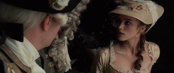 Movie still from “Pirates of the Caribbean: The Curse of the Black Pearl” (2003), directed by Gore Verbinski – Two people in period costumes and a hat; Close Up shot, Over the shoulder angle