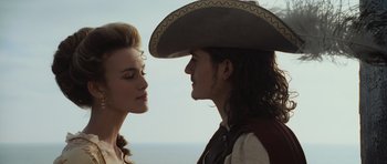 Movie still from “Pirates of the Caribbean: The Curse of the Black Pearl” (2003), directed by Gore Verbinski – A man and a woman are kissing each other in front of the ocean; Close Up shot, Over the shoulder angle