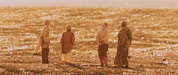 Movie still from “Pitch Black” (2000), directed by David Twohy – A group of people standing on top of a sandy beach; Extreme Wide shot, Low angle