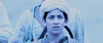 Movie still from “Pitch Black” (2000), directed by David Twohy – A young man wearing a turban is looking into the camera; Close Up shot, Low angle