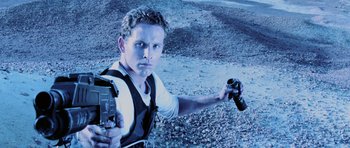 Movie still from “Pitch Black” (2000), directed by David Twohy – A man holding a video game controller in his hand; Close Up shot, Low angle