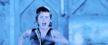 Movie still from “Pitch Black” (2000), directed by David Twohy – A person with a hat and a microphone in their mouth; Close Up shot, Low angle