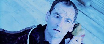 Movie still from “Pitch Black” (2000), directed by David Twohy – A person wearing glasses and holding a hair brush; Close Up shot, Overhead angle