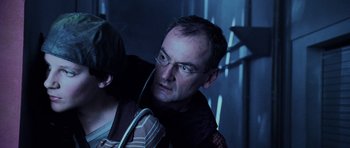 Movie still from “Pitch Black” (2000), directed by David Twohy – A man with glasses is looking into the distance; Close Up shot, Over the shoulder angle