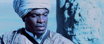 Movie still from “Pitch Black” (2000), directed by David Twohy – A person wearing a turban; Close Up shot, Low angle