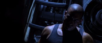 Movie still from “Pitch Black” (2000), directed by David Twohy – A person wearing a tank top; Close Up shot, Low angle