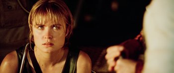 Movie still from “Pitch Black” (2000), directed by David Twohy – A person sitting down looking at the camera; Close Up shot, Over the shoulder angle