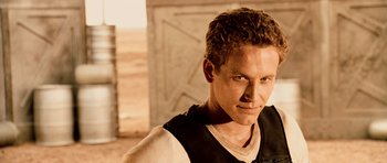 Movie still from “Pitch Black” (2000), directed by David Twohy – A man with a beard is looking at the camera; Close Up shot, Over the shoulder angle