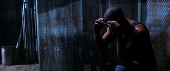 Movie still from “Pitch Black” (2000), directed by David Twohy – A man holding a razor in front of his face; Close Up shot, Low angle