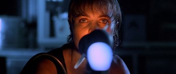 Movie still from “Pitch Black” (2000), directed by David Twohy – A woman is looking through a telescope at the sky; Close Up shot, Low angle