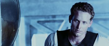 Movie still from “Pitch Black” (2000), directed by David Twohy – A person wearing a vest; Close Up shot, Low angle