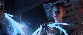 Movie still from “Pitch Black” (2000), directed by David Twohy – A young man holding a steering wheel in a garage; Medium shot, Low angle
