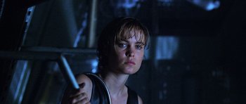 Movie still from “Pitch Black” (2000), directed by David Twohy – A woman holding a remote control in a dark room; Close Up shot, Low angle