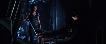 Movie still from “Pitch Black” (2000), directed by David Twohy – Two people in a dark room , one of whom is holding a sword; Medium shot, Low angle