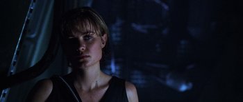 Movie still from “Pitch Black” (2000), directed by David Twohy – A woman in a black top is in a dark room; Close Up shot, Low angle
