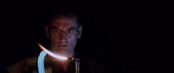 Movie still from “Pitch Black” (2000), directed by David Twohy – A man with a glowing light around his neck; Close Up shot, Low angle