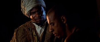 Movie still from “Pitch Black” (2000), directed by David Twohy – A man and a man with a turban on; Close Up shot, Over the shoulder angle