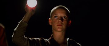 Movie still from “Pitch Black” (2000), directed by David Twohy – A woman with a shaved head looking up at a light; Close Up shot, Low angle