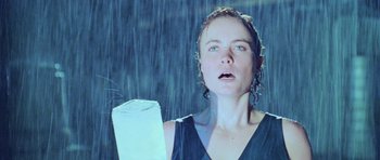 Movie still from “Pitch Black” (2000), directed by David Twohy – A woman holding onto a toilet paper roll while standing in the rain; Close Up shot, Low angle
