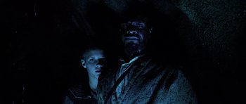 Movie still from “Pitch Black” (2000), directed by David Twohy – A man and a woman standing next to each other in the dark; Medium shot, Low angle