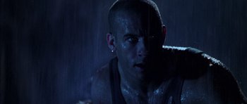 Movie still from “Pitch Black” (2000), directed by David Twohy – A person in the rain; Close Up shot, Low angle