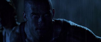 Movie still from “Pitch Black” (2000), directed by David Twohy – A man's face in the rain; Close Up shot, Low angle