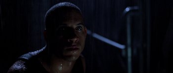 Movie still from “Pitch Black” (2000), directed by David Twohy – A person in the rain; Close Up shot, Low angle