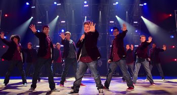 Movie still from “Pitch Perfect” (2012), directed by Jason Moore – A group of men standing on a dance floor; Wide shot, Overhead angle