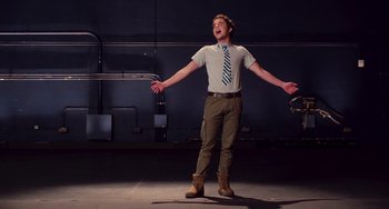 Movie still from “Pitch Perfect” (2012), directed by Jason Moore – A young man standing in the middle of an indoor area; Medium shot, Low angle