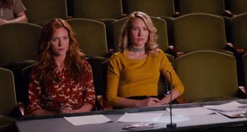 Movie still from “Pitch Perfect” (2012), directed by Jason Moore – Two women sitting at a table in front of a microphone; Medium shot, High angle