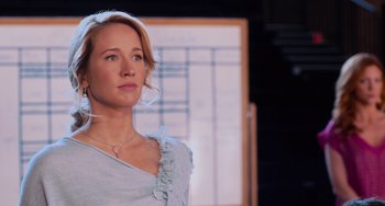 Movie still from “Pitch Perfect” (2012), directed by Jason Moore – A woman standing in front of a window looking to her left; Close Up shot, Over the shoulder angle