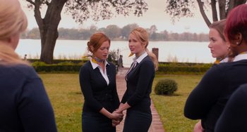 Movie still from “Pitch Perfect” (2012), directed by Jason Moore – A couple of women standing next to each other on a walkway; Medium shot, Over the shoulder angle