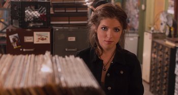 Movie still from “Pitch Perfect” (2012), directed by Jason Moore – A woman standing in front of a stack of papers in an office; Close Up shot, Overhead angle
