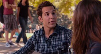 Movie still from “Pitch Perfect” (2012), directed by Jason Moore – A young man sitting in front of a woman in a park; Close Up shot, Over the shoulder angle