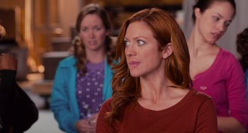 Movie still from “Pitch Perfect” (2012), directed by Jason Moore – A woman with long red hair is looking to her left; Close Up shot, Over the shoulder angle