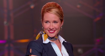 Movie still from “Pitch Perfect” (2012), directed by Jason Moore – A woman wearing a blue jacket and a yellow neck scarf; Close Up shot, Low angle