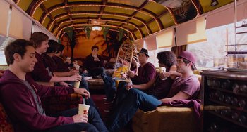 Movie still from “Pitch Perfect” (2012), directed by Jason Moore – A group of men sitting on a couch eating and drinking; Wide shot, High angle