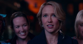 Movie still from “Pitch Perfect” (2012), directed by Jason Moore – Two women smiling for the camera in a dark room; Close Up shot, Over the shoulder angle