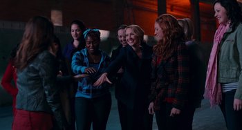 Movie still from “Pitch Perfect” (2012), directed by Jason Moore – A group of people standing next to each other in a room; Medium shot, Over the shoulder angle