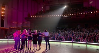 Movie still from “Pitch Perfect” (2012), directed by Jason Moore – A group of women standing in front of an audience in front of a crowd; Extreme Wide shot, High angle