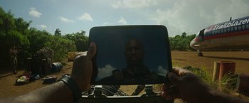 Movie still from “Plane” (2023), directed by Jean-François Richet – A person holding a tablet in their hand; Extreme Close Up shot, Overhead angle