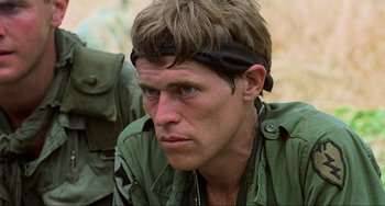 Movie still from “Platoon” (1986), directed by Oliver Stone – A person wearing a headband; Close Up shot, Over the shoulder angle