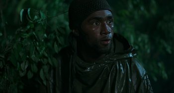 Movie still from “Platoon” (1986), directed by Oliver Stone – A man in a rain jacket and a hat; Close Up shot, High angle