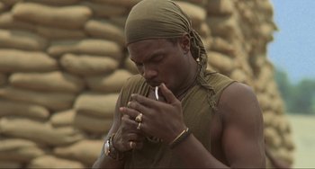 Movie still from “Platoon” (1986), directed by Oliver Stone – A man with a bandanna is smoking a cigarette; Close Up shot, Low angle