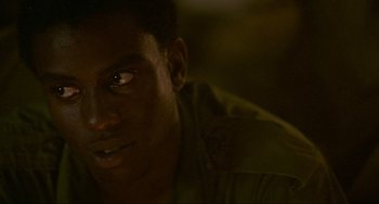 Movie still from “Platoon” (1986), directed by Oliver Stone – A man's face in the dark; Close Up shot, Over the shoulder angle
