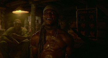 Movie still from “Platoon” (1986), directed by Oliver Stone – A shirtless man with a bandana around his neck; Medium shot, Low angle