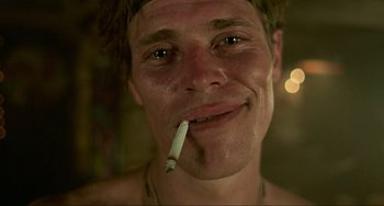 Movie still from “Platoon” (1986), directed by Oliver Stone – A person smoking a cigarette; Close Up shot, Low angle