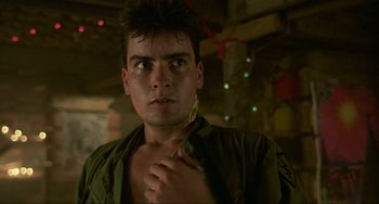 Movie still from “Platoon” (1986), directed by Oliver Stone – A young man with a green shirt is posing for a picture; Close Up shot, Low angle